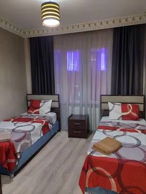 a bedroom with two beds and a window with curtains at Çelebi Suite Home in Istanbul