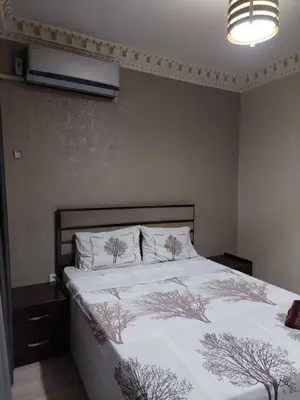 a bedroom with a bed with white sheets and trees on it at Çelebi Suite Home in Istanbul