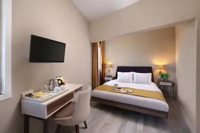 a hotel room with a bed and a desk and a tv at Almina Hotel - Special Class in Istanbul