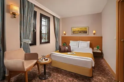 a hotel room with a bed and a chair at Almina Hotel - Special Class in Istanbul