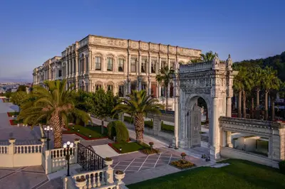 a large building with palm trees in front of it at Çırağan Palace Kempinski Istanbul in Istanbul