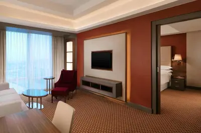 a hotel room with a large mirror and a suite at Sheraton Bursa Hotel in Bursa