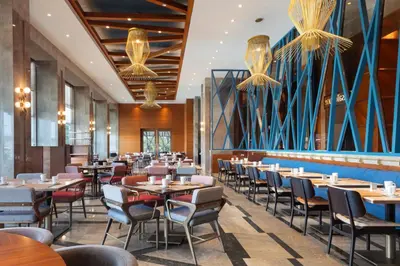 a dining room with tables and chairs and chandeliers at Sheraton Bursa Hotel in Bursa