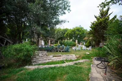 a garden with some rocks and chairs and trees at Ağva Acquaverde Otel in Agva