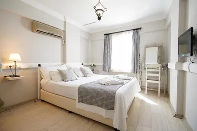 a white bedroom with a bed and a window at Ağva Acquaverde Otel in Agva