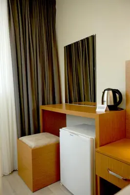a room with a refrigerator and a table and a curtain at Kartal Palace Taksim Square FAMILY HOTEL in Istanbul
