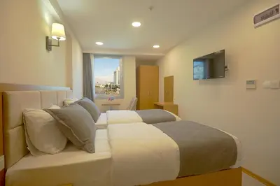 a bedroom with a bed and a tv on the wall at Kartal Palace Taksim Square FAMILY HOTEL in Istanbul