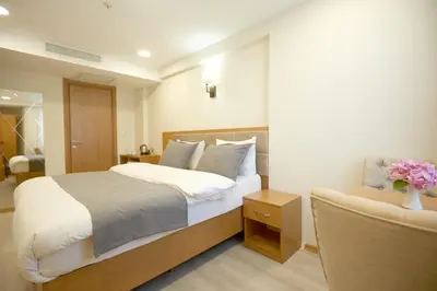 a bedroom with a large bed and a chair at Kartal Palace Taksim Square FAMILY HOTEL in Istanbul