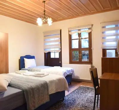 a bedroom with two beds and two windows at ÖZ Butik Otel Antik Kent Myrleia in Mudanya