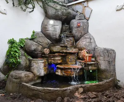 a waterfall in the side of a building with a stone fountain at ÖZ Butik Otel Antik Kent Myrleia in Mudanya