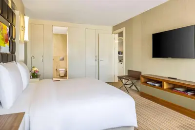 a bedroom with a large white bed and a flat screen tv at Ramada Plaza By Wyndham Istanbul Tekstilkent in Istanbul