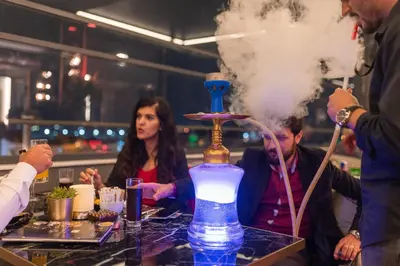a group of people sitting around a table with a smoking bottle at Grand Washington Hotel in Istanbul