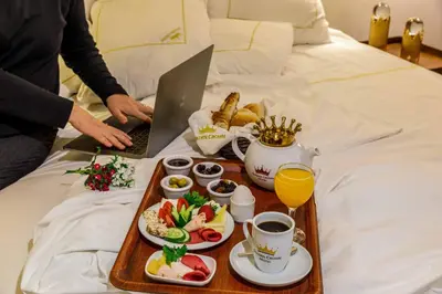 a tray of food on a bed with a laptop at Golden Crown Hotel in Istanbul
