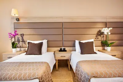 two beds in a hotel room with flowers at Nidya Hotel Galataport in Istanbul