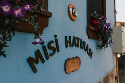 a sign on the side of a building with flowers at Misgibi Hotel in Bursa