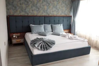 a bedroom with a large bed with a blue headboard at Avrasya Port Hotel in Istanbul