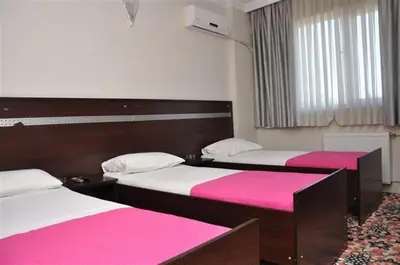two beds in a room with pink and white sheets at Topkapı Otel Özyavuz in Istanbul