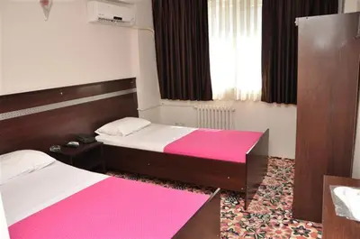 a bedroom with two beds with pink and white sheets at Topkapı Otel Özyavuz in Istanbul