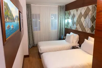 a hotel room with two beds and a painting on the wall at Long Stay İstanbul Hotel in Istanbul