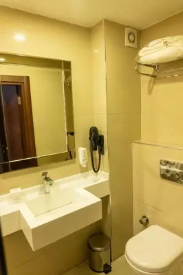 a bathroom with a sink and a toilet and a phone at Long Stay İstanbul Hotel in Istanbul