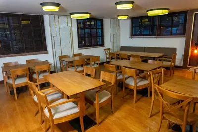 a restaurant with wooden tables and chairs and windows at Long Stay İstanbul Hotel in Istanbul
