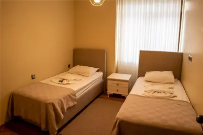 two beds in a small room with a window at My Palace Aırport in Istanbul