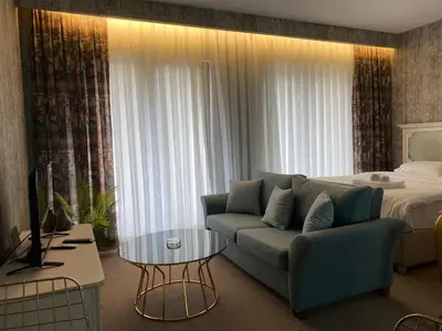 a living room with a couch and a bed at My Palace Aırport in Istanbul