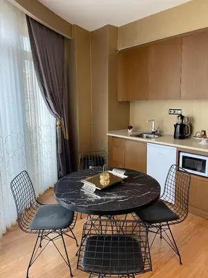 a kitchen with a black table and chairs in a room at My Palace Aırport in Istanbul