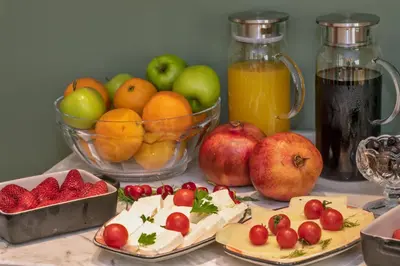 a table topped with plates of fruit and a bowl of apples at Nika otel & cafe in Istanbul