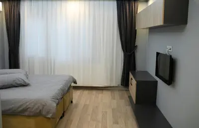 a bedroom with a bed and a flat screen tv at Sare House in Istanbul