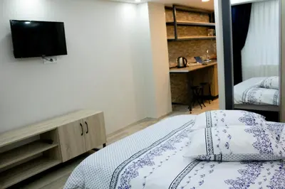 a bedroom with a bed with a television and a desk at Sare House in Istanbul