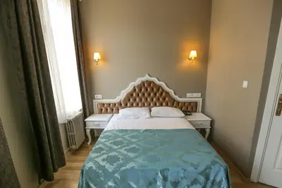 a bedroom with a bed and two tables and a window at Şehir Hotel Old City in Istanbul