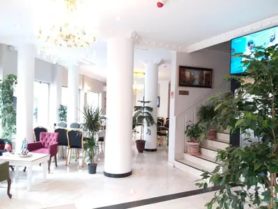 a lobby with columns and tables and plants at Şehir Hotel Old City in Istanbul