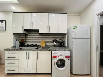 a kitchen with white cabinets and a washing machine at Westley Residence Taksim in Istanbul