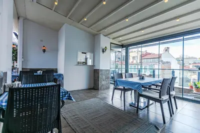 a dining room with a table and chairs and windows at Stanpoli Hostel in Istanbul
