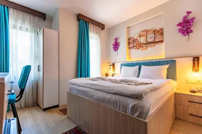 a bedroom with a large bed with blue curtains at Stanpoli Hostel in Istanbul