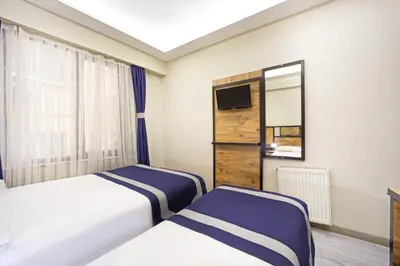 a hotel room with two beds and a tv at Vizyon Hotel - Old City in Istanbul