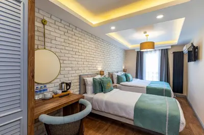 a bedroom with two beds and a table and a mirror at Interstar Hotel - Sultanahmet in Istanbul