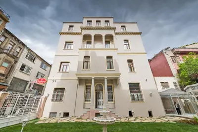 a large white building with a clock in front of it at Enderun Hotel Istanbul in Istanbul