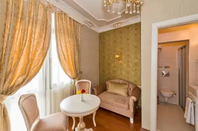 a living room with a table and a chair and a couch at Enderun Hotel Istanbul in Istanbul