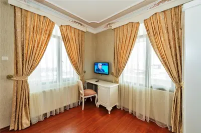 a room with curtains and a desk and a television at Enderun Hotel Istanbul in Istanbul