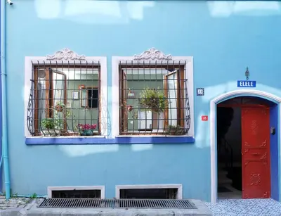 a blue building with two windows and a red door at Elele Aparts in Istanbul