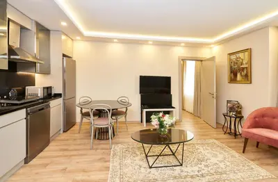 a living room with a table and a kitchen at All Seasons Suites in Istanbul