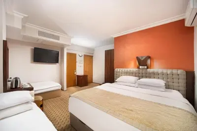 a hotel room with two beds and a flat screen tv at Elan Hotel Istanbul Pera in Istanbul