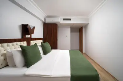 a bedroom with a large white bed with green pillows at Elan Hotel Istanbul Pera in Istanbul