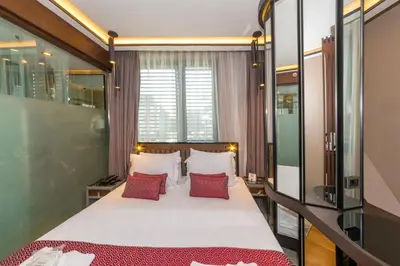 a bedroom with a large bed with red pillows at Opale Hotel in Istanbul