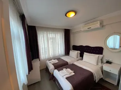 a hotel room with two beds and a mirror at Spinel Hotel - Old City in Istanbul