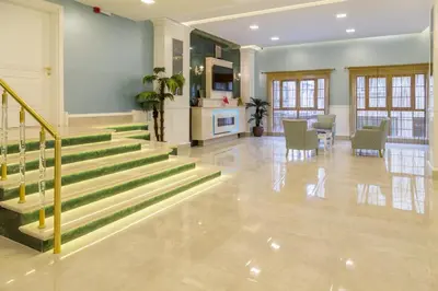 a lobby with stairs and a table and chairs at Bursa Palas Hotel in Bursa