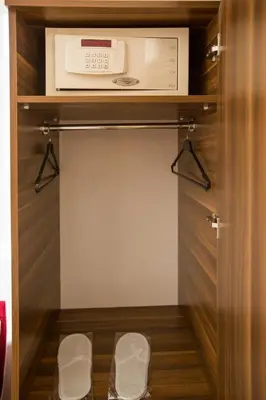 a walk in closet with a microwave and two stools at Corner Garden Hotel in Istanbul
