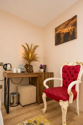 a living room with a red chair and a desk at Corner Garden Hotel in Istanbul